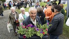 <span lang= gl >Un visitante sae con varias plantas da feira, nunha imaxe de arquivo</span>