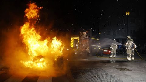 Bomberos, apagando uno de los contenedores incendiados por manifestantes en la ciudad de A Coru�a el mi�rcoles pasado.