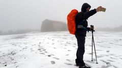 Un peregrino portugu�s del Camino de Invierno visitando el santuario de O Faro durante una nevada