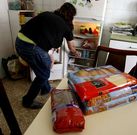 Lidia, con su beb� en brazos, coloca algunos de los v�veres que ha recibido su familia. 