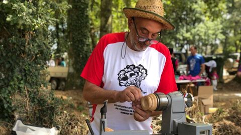 Un artesano trabaja la madera durante la Muestra de Artesana, en la XXX Romara Labrega da Chaira (Guitiriz).