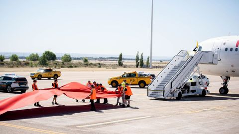 Los trabajadores, colocando la alfombra roja en plena pista