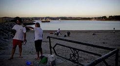 Los �ltimos ba�istas, abandonando el arenal al atardecer, cuando se manten�a la bandera roja.