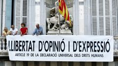 La Junta Electoral da a Torra dos d�as para retirar pancartas. La Junta  Electoral ha ordenado a Torra retirar todo tipo de lazos y carteles de los edificios de la Generalitat antes de las tres de la tarde del viernes bajo amenaza de �medidas penales�, para conservar la neutralidad de los poderes p�blicos. Torra est� pendiente de ser juzgado por no quitar en tiempo los lazos en las pasadas elecciones. La pancarta de la imagen sustituy� el pasado d�a 27 a la de los �presos pol�ticos y exiliados�, en un intento de sortear la ley 