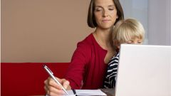 Madre trabajando con un portatil mientras cuida un ni�o