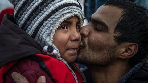 Un hombre besa a una ni�a que llora en la isla griega de Lesbos