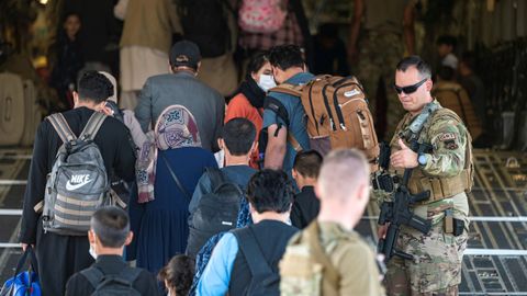 Miembros de las fuerzas militares escoltan a un grupo de ciudadanos antes de embarcar en un avin en el aeropuerto de la ciudad de Kabul