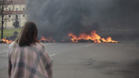Una mujer ante la barricada de neum�ticos en llamas