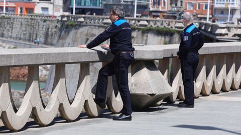 Dos polic�as  vigilan la la gente paseando por el paseo mar�timo y por la playa en A Coru�a