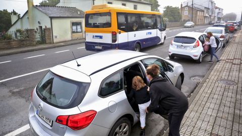 Los pequeos de Baamonde suben al coche mientras el autobs escolar pasa de largo.