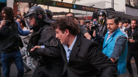 El youtubero libertario Fran Fijap, agredido durante las manifestaciones de este jueves en Buenos Aires, es escoltado por la policía.