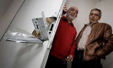 Dos vecinos de Novo Mesoiro ante una de las puertas forzadas.