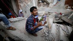 Un hombre busca a una familiar entre las ruinas del Rana Plaza.