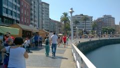 Paseantes  por el puerto deportivo, con el Mercad�n de la Sidra y la Manzana del Festival de la Sidra