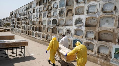 Sepultureros transportan el ataud de un fallecido por coronavirus en Lima