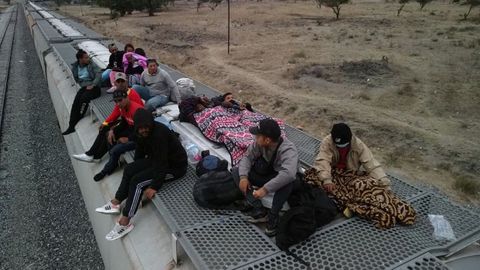 Migrantes venezolanos descansan sobre unos vagones en México en su viaje hacia la frontera con Estados Unidos.