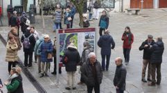 Integrantes de una excursin en grupo hacen tiempo en Monforte junto a un indicador con informacin turstica