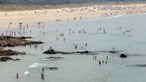 Mucha gente en el agua en A Lanzada 