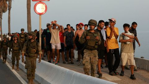 Militares escoltando a inmigrantes en Ceuta.