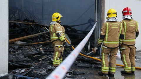Los bomberos comarcales actuando en el incendio que arras� la nave de Trison en Sada