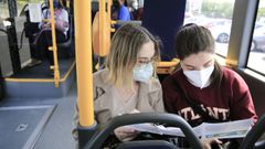 Dos chicas miran con atenci�n las nuevas l�neas de bus