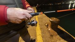Un pescador disfruta de su afici�n en el puerto de Laxe.