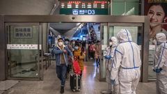Trabajadores y pasajeros en una estaci�n de tren de Wuhan