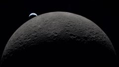 Primer plano de la cara oculta de la Luna con la Tierra al fondo realizada desde la nave Orion