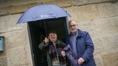 Manuel Pedro Fern�ndez, derecha, entrega un paraguas a un vecino