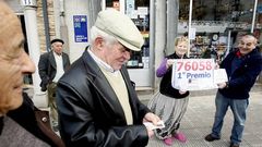 Un vecino comprueba su cup�n ante los due�os de la administraci�n de Meira donde se vendieron dos d�cimos del Gordo.