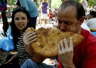 Uno de los asistentes a la fiesta empieza a comerse su �raci�n� de empanada.