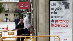 Clientes en la puerta de un banco en la calle Cardenal, en la que casi todos los negocios est�n cerrados