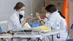 Dos trabajadoras sanitarias preparan dosis de AstraZeneca para su administraci�n en el Pazo de Congresos de Pontevedra