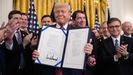 Trump posa con una ley firmada en la Casa Blanca.
