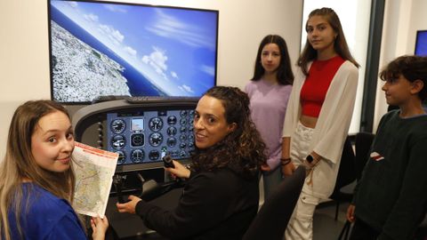Un grupo de estudiantes con una de las profesoras que les ensea el funcionamiento del simulador de vuelo