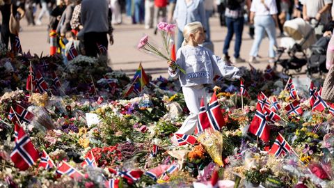 Una ni�a con unas flores delante el palacio real de Oslo, en homenaje al rey Harald