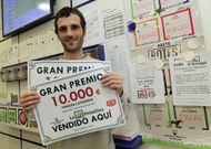 Francisco Requeijo mostrando el cartel del premio en su estanco de la calle Pastor D�az. 