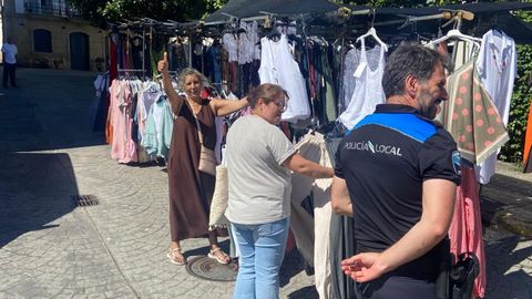 Un polic�a local inspecciona los puestos del mercado semanal de Mugardos