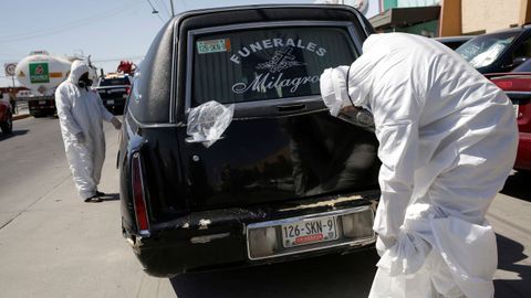 Trabajadores de una funeraria de Ciudad Juárez, en México, con los trajes de protección