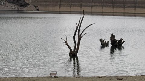 Barro y rboles sumergidos. Este es el aspecto que presenta el embalse hoy, con algunos rboles sumergidos ya visibles y barro a la vista en las orillas. En la foto se ve una silla de playa abandonada