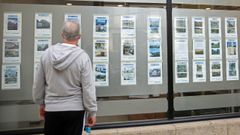 Imagen de archivo de un hombre consultando anuncios en una inmobiliaria.