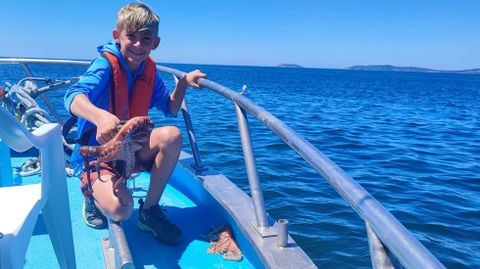 Uno de los turistas norteamericanos con un pulpo en la actividad de pescaturismo del Playa de Sanxenxo