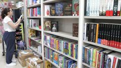 Ant�a Carou, empleada de El Cisne, colocando libros en una estanter�a