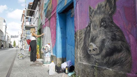 En la calle Alonso Lpez la artista Yanina Torres elabora un mural con jabales