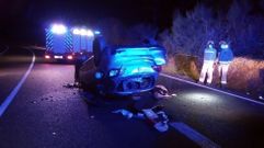Bomberos junto al coche accidentado esta noche en la carretera N-120 cerca de Ferreira de Pant�n