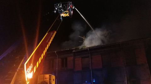 Bomberos trabajan en la extinci�n de un incendio en un edificio abandonado en Jove