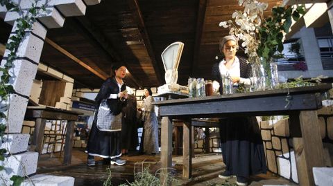 B�scula y tarros de hierbas medicinales en el carro de la herborister�a