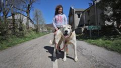 Eva y su perro Firul�is, junto a la casa familiar en la frontera gallega en la que se instal�