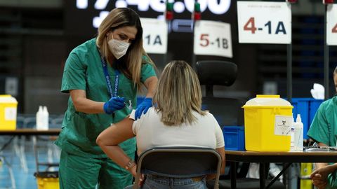 Una mujer, vacun�ndose en las instalaciones del Pabell�n Santiago Mart�n, en La Laguna