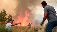 Los vecinos de la Guarda colaborando este martes en las tareas de extinci�n.